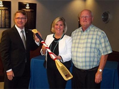 ONWASA's CEO, Jeffery L. Hudson, presents ceremonial oar to Rebecca Blount, GUC Board chair, and Randy Emory