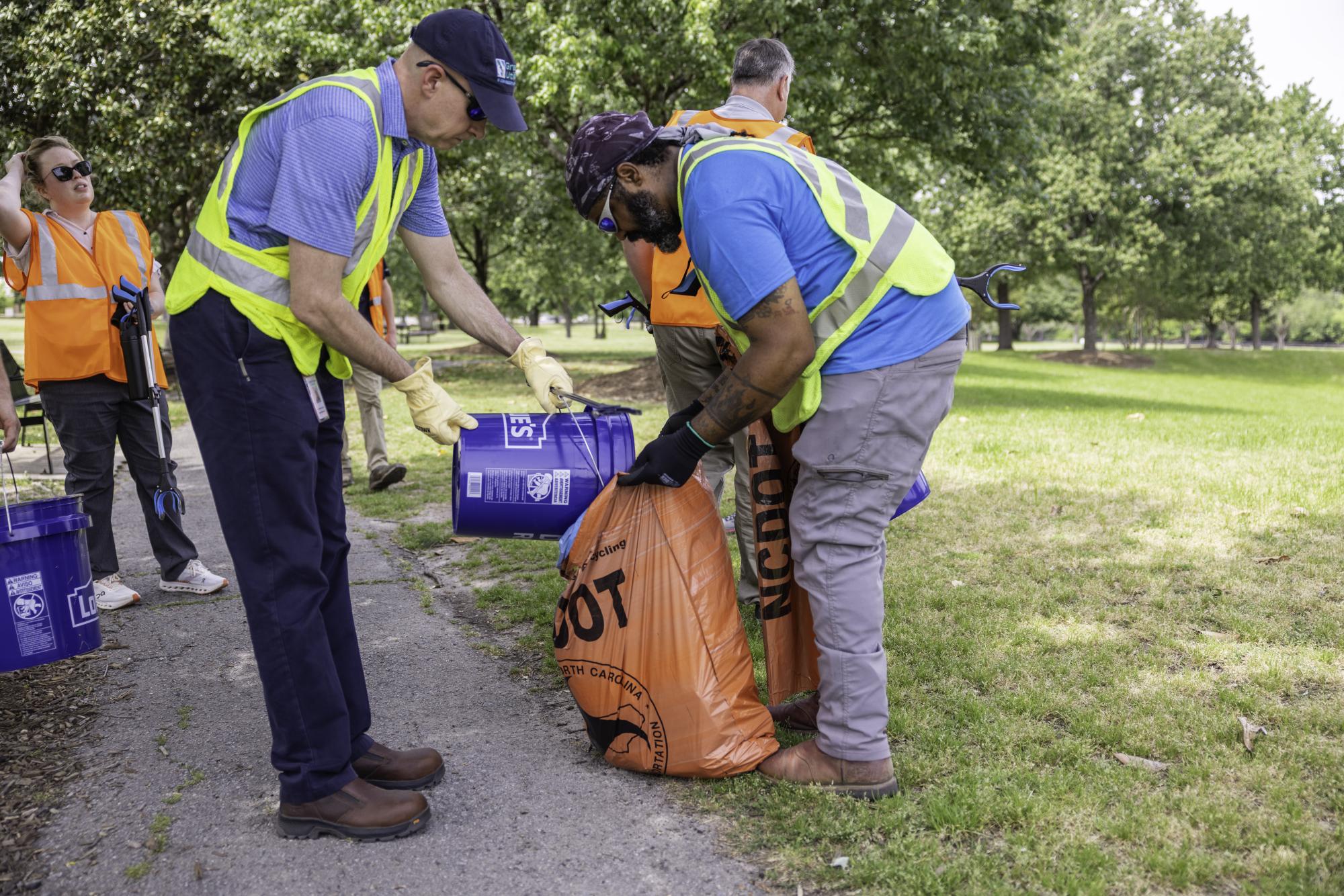 Two men pick up litter.
