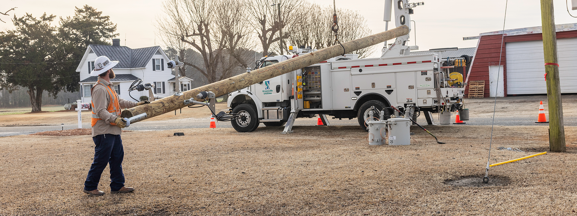Linemen install power line pole