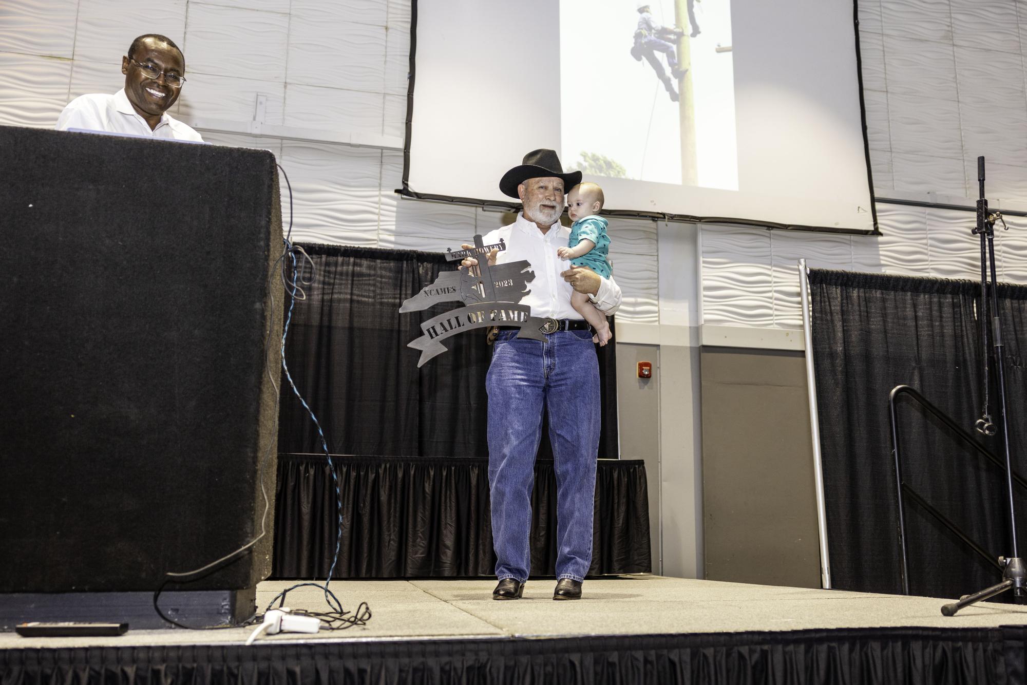 Mark Howery accepting the Hall of Fame award with his great-grandson.